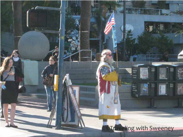 "Man with Flag near Occupy SF encampment at Justin Herman Plaza"