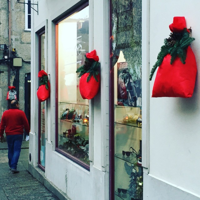 Decorative red sacks and evergreen bows adorn buildings for Christmas