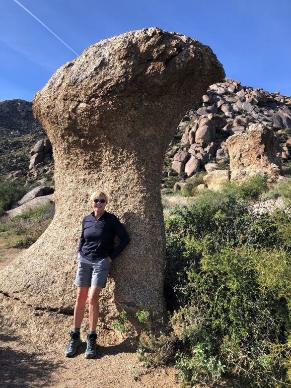 Standing next to a huge mushroom-shaped rock on the Marcus Landslide Trail in the Sonoran Desert of Scottdale, Arizona