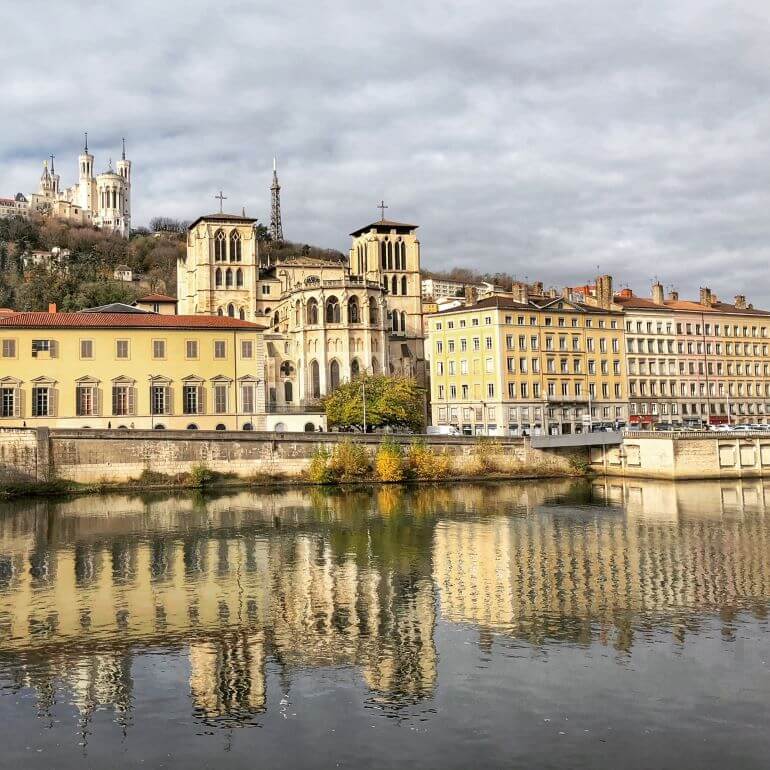 Lyon, France -- view from a bridge on the Saône of the basilica and tower on Fourvière Hill and the cathedral in the foreground.