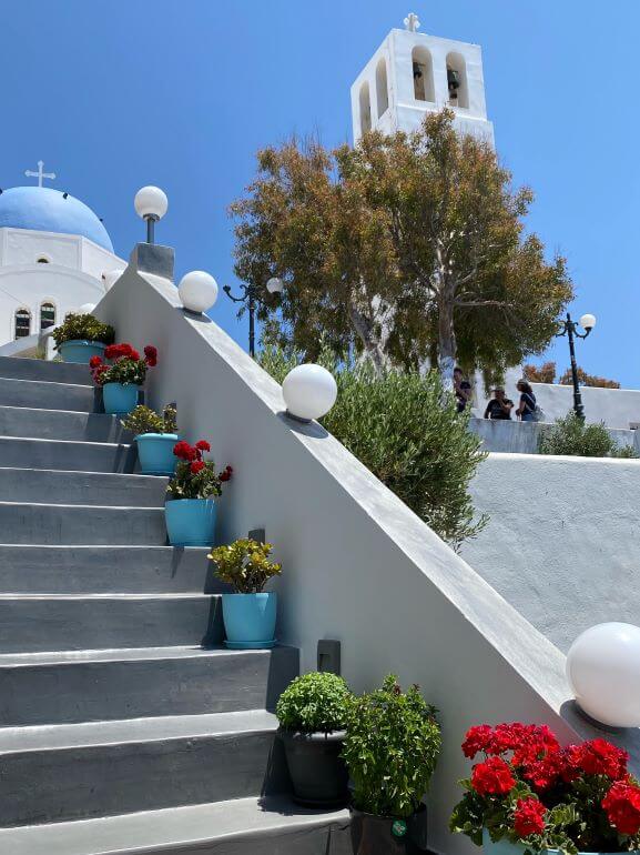 Quintessential Santorini -- blue domed church, white-washed walls, and flower pots. Santorini, Greece