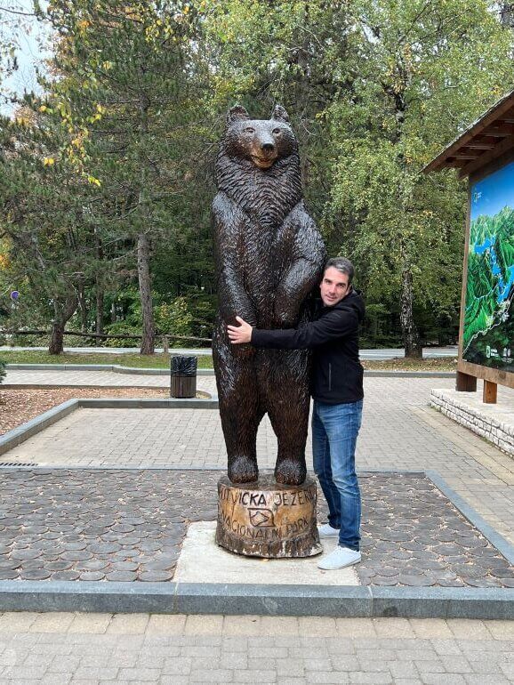Collette "Taste of the Balkans" tour manager, Djukan Djukanovic hugging the bear at Plitvice Lakes National Park in Croatia
