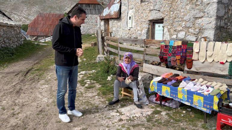 Collette tour manager, Djukan Djukanovic, talking to local woman in Lukomir, Bosnia