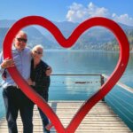 Catherine Sweeney and Mr. Traveling with Sweeney at the heart sculpture on a dock at Lake Bled, Slovenia