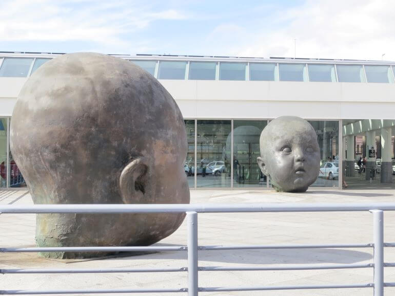 Day and Night baby head sculptures by Spanish artist Antonio López García at Atocha station in Madrid, Spain