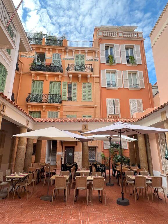 Al fresco dining next to colorful buildings of Monaco City