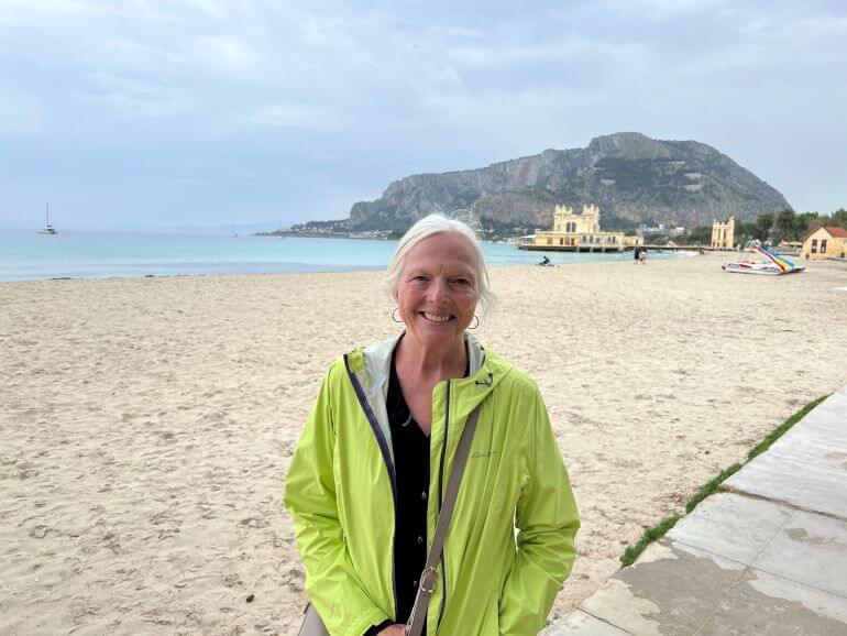 Catherine Sweeney on a sandy beach of Mondello, Sicily, Italy -- lovely even on a cool, overcast day