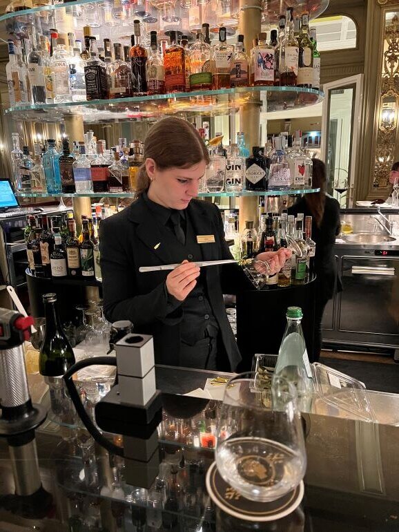 Mixologist at the Grand Hotel et des Palmes Hotel in Palermo, Sicily, Italy applies a gold leaf pattern on a cocktail glass