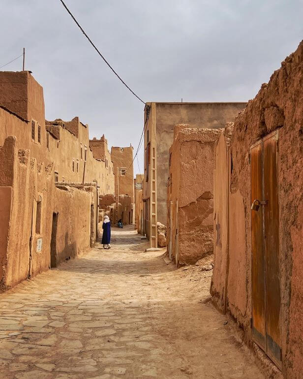 A woman walks through a street in the El Khorbat, Morocco