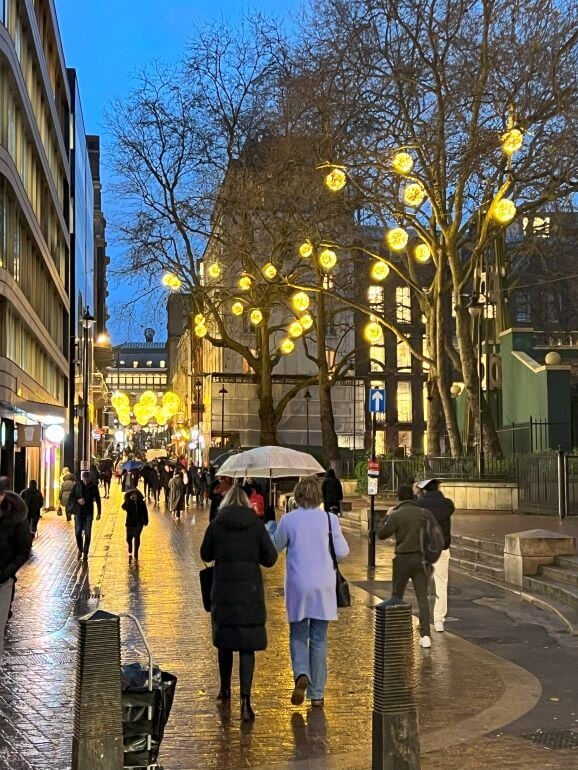 People walking in Covent Garden on a rainy night in London