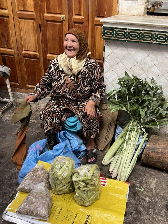 Woman selling produce at Fes medina, Morocco