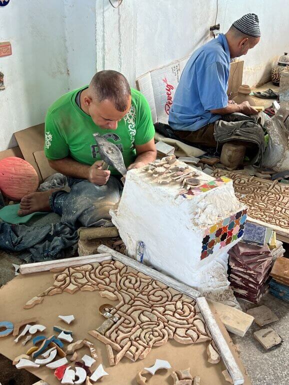 Artisans at work on mosaic and ceramic products at Art Naji in Fes, Morocco