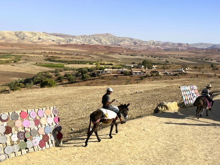 Boy riding donkey, Moroccan crafts for sale, at a view point of the valley and mountains on a Collette tour