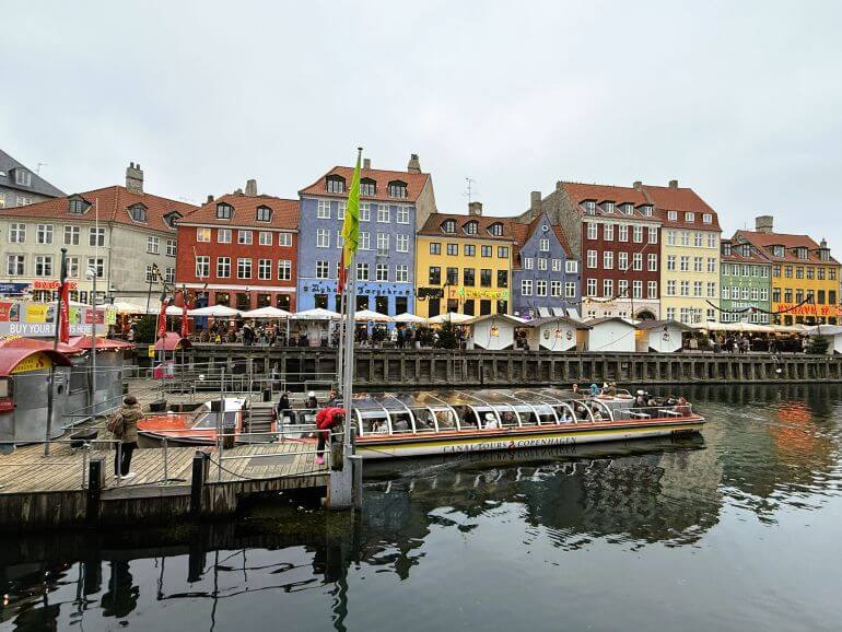 Boat on the canal, colorful buildings at Nyhavn, Copenhagen, Denmark
